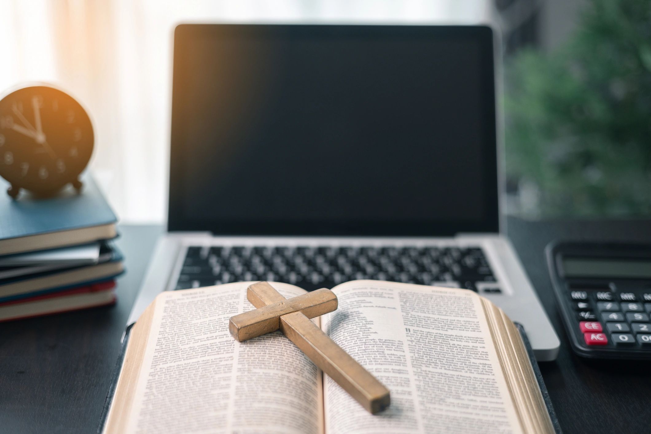 Open Bible and laptop on a desk for online Bible study